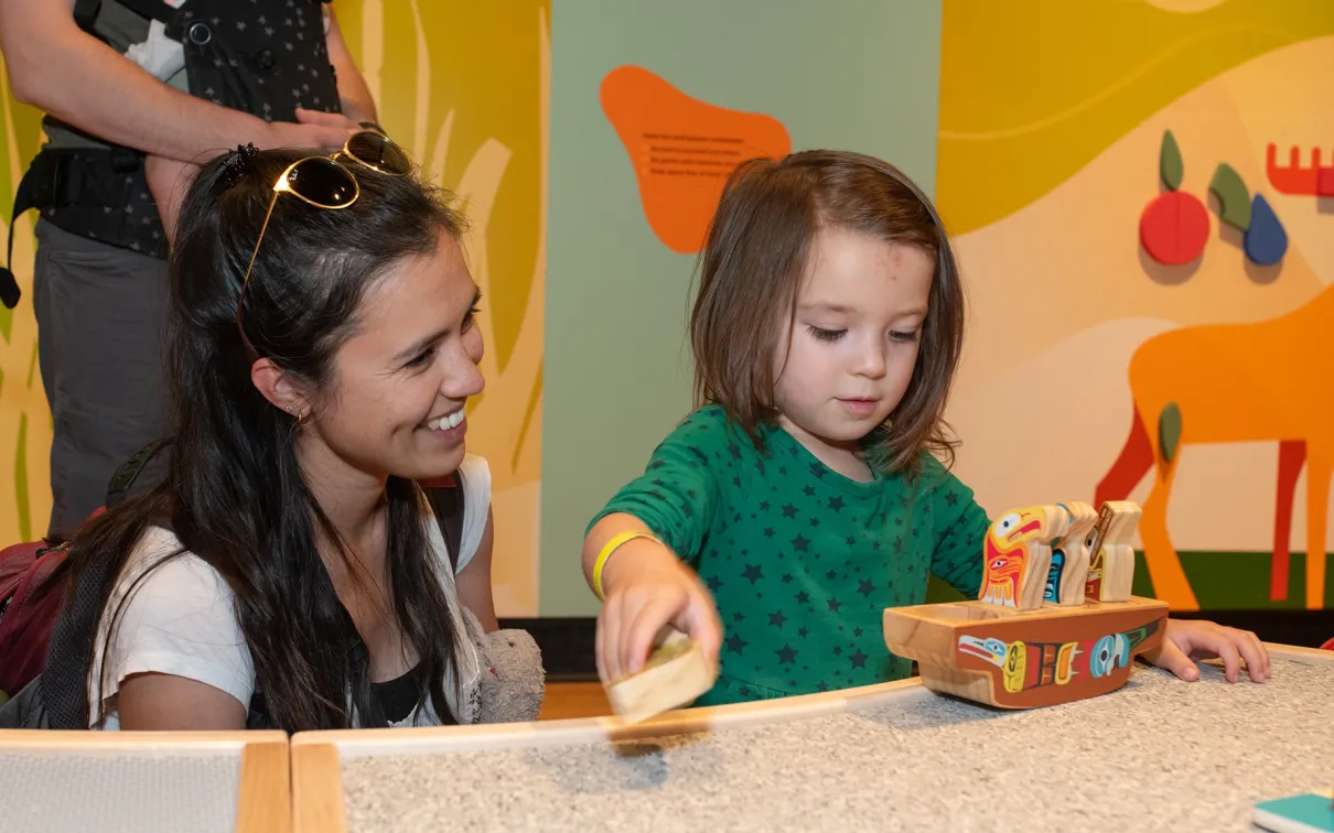 Child enjoying ROM Kids Junior program with parent watching