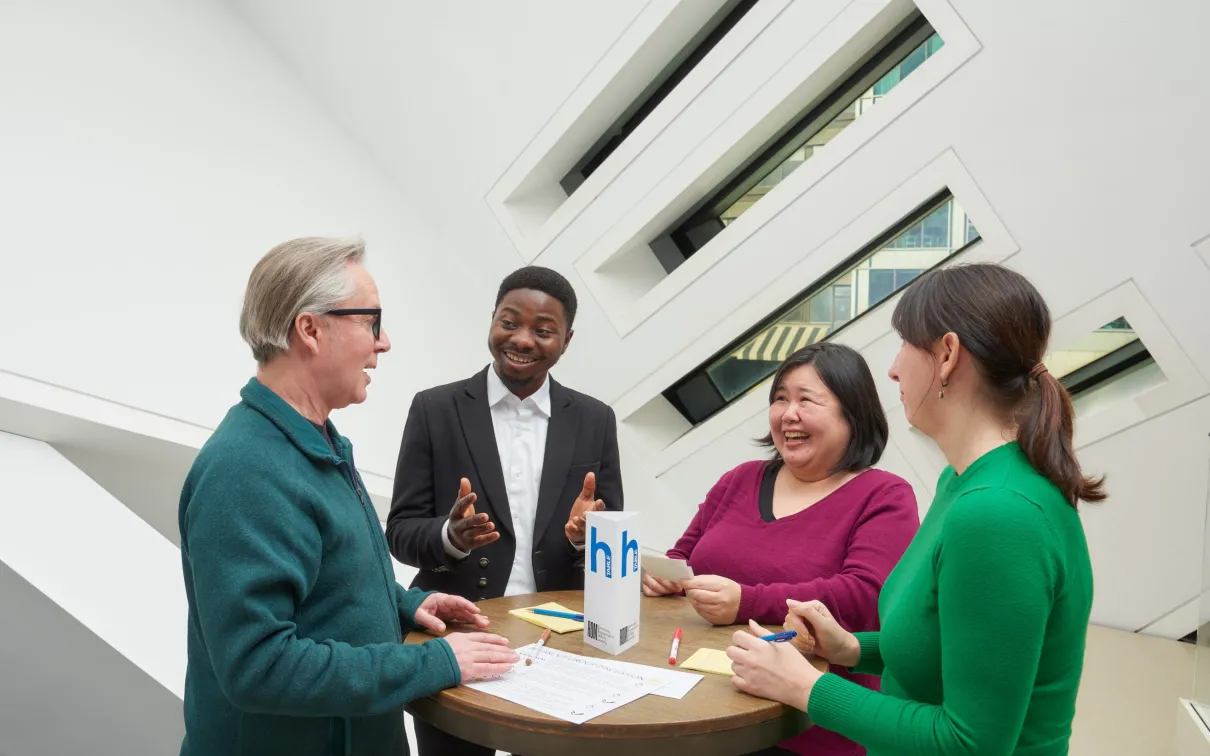four people sitting at a table, having a fun conversation practicing English at the Royal Ontario Museum