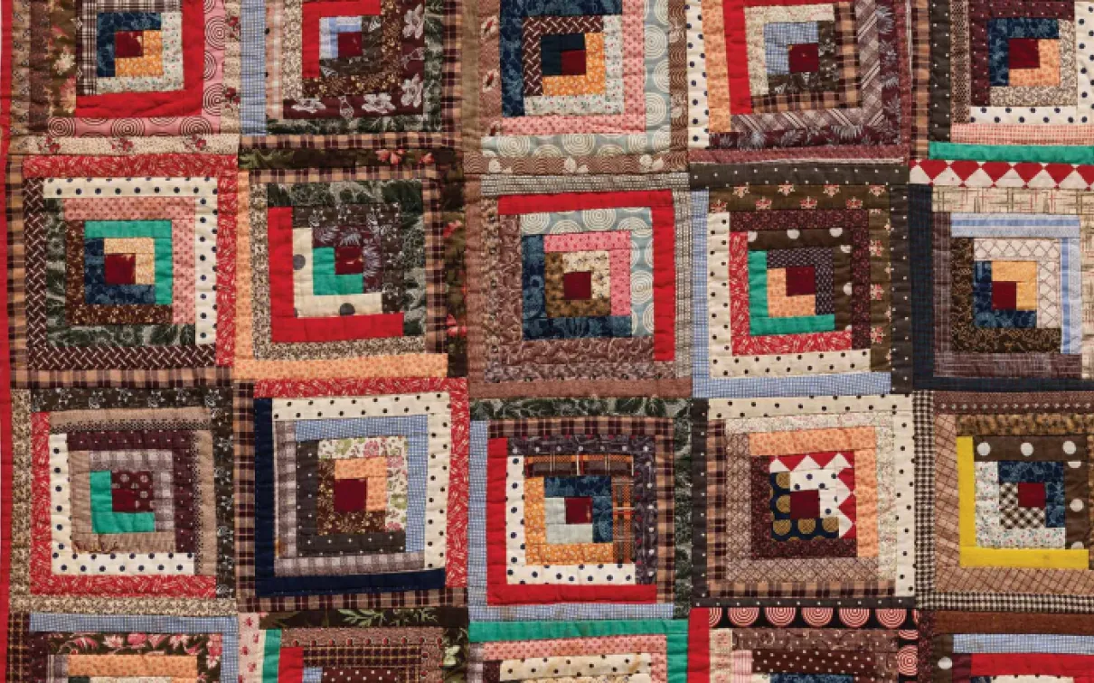 A vibrant quilt featuring an array of colorful squares, showcasing a patchwork of diverse patterns and hues.