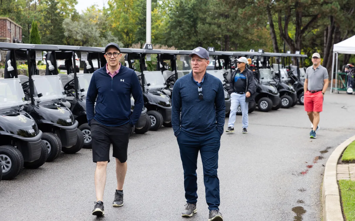 Two male golfers walking to the golf course