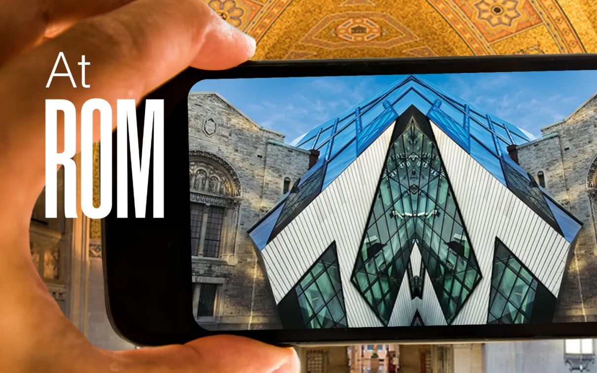 A hand holds up a phone displaying an image of the Royal Ontario Museum mirrored down the middle. Text reads at ROM.