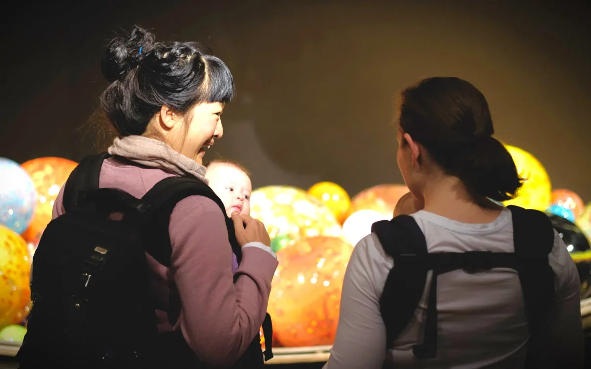 Two mothers carry with their baby in a carrier bag at ROM 