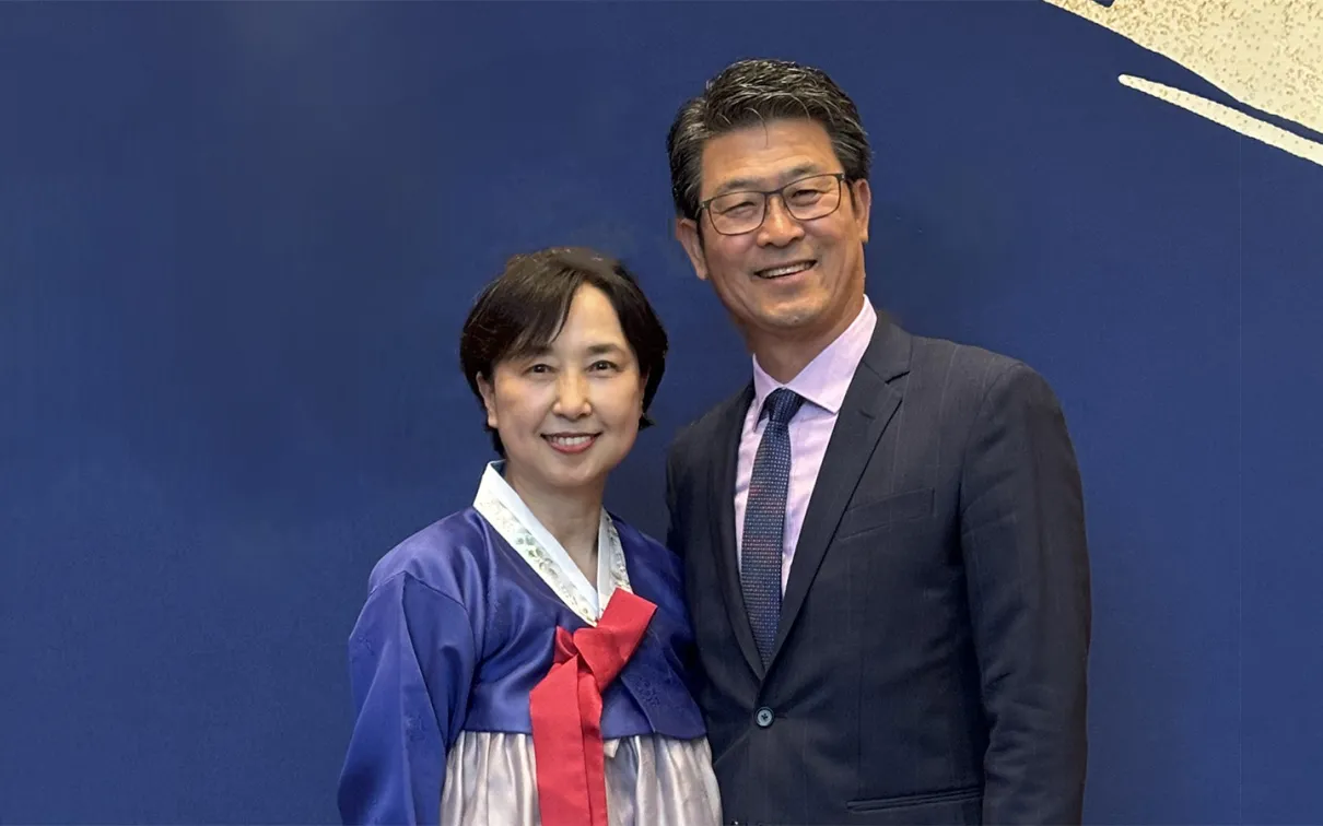 Woman and man in front of a blue background