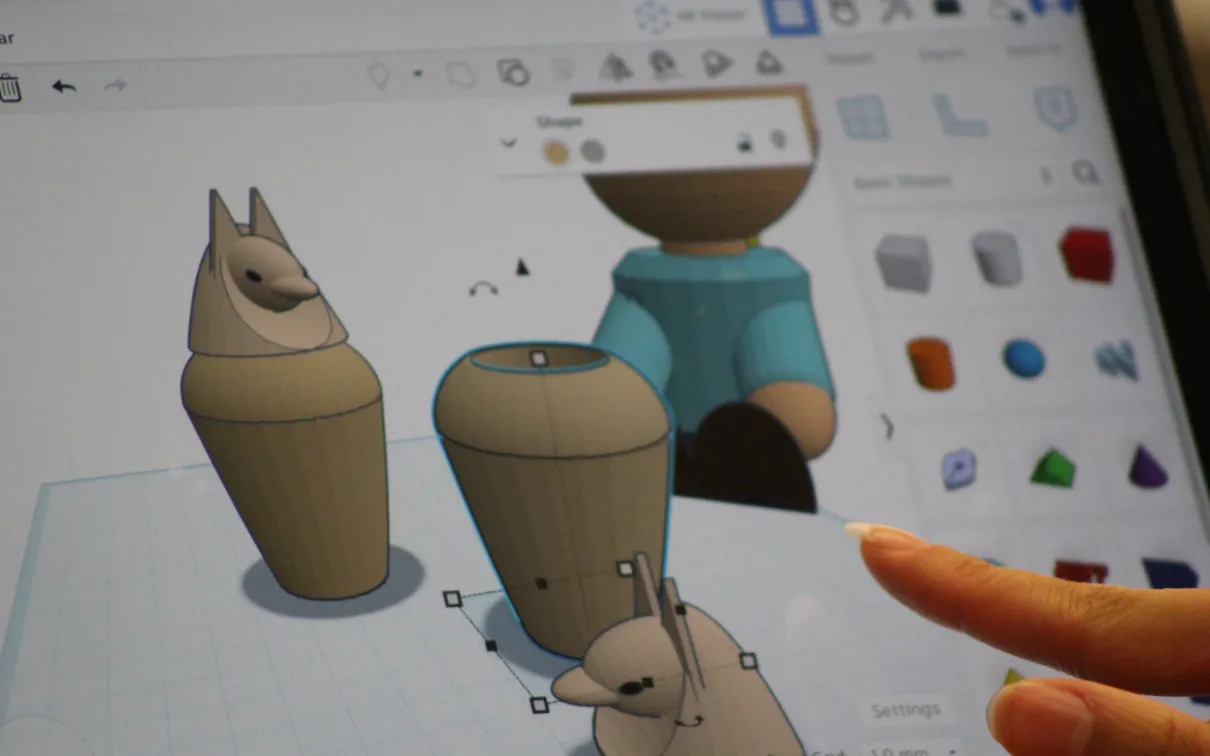An ipad screen displays a program creating 3D models of canopic jars