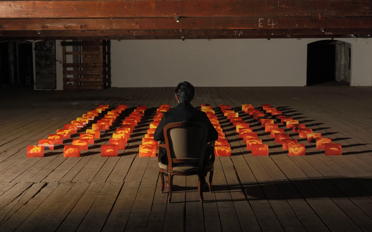 Man sitting in front of photographs.
