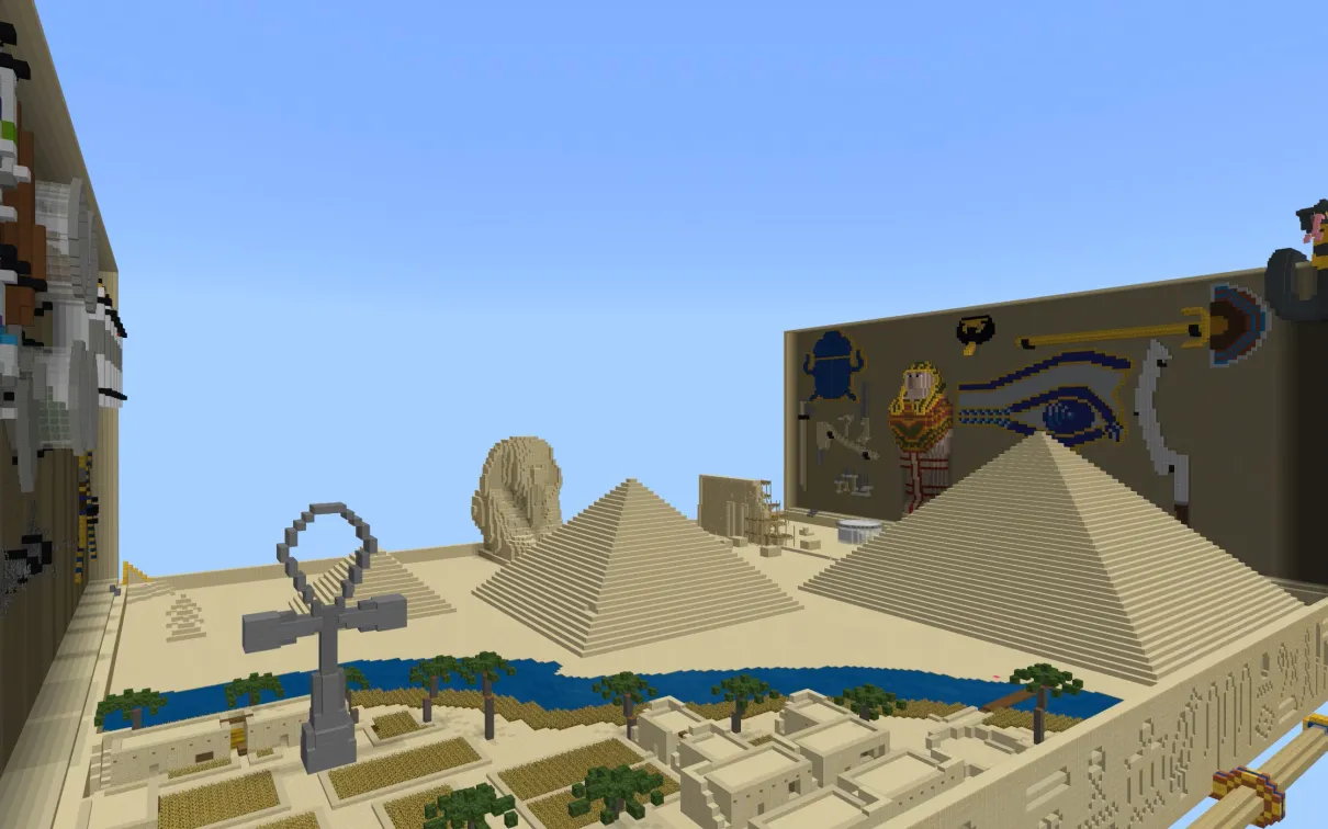 A minecraft screenshot showing a desert crossed by a blue river, pyramids, a giant ankh, and other Egyptian elements