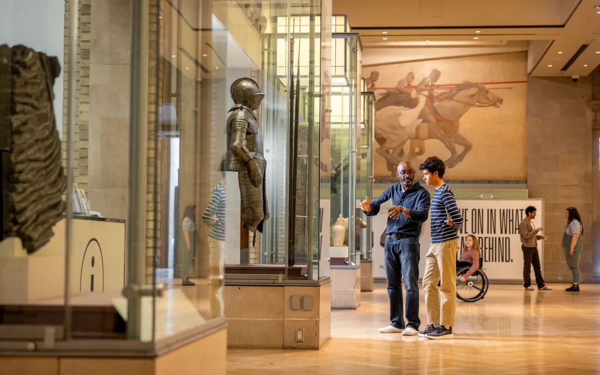 Two people looking and discussing a case of a knife in Currelly gallery