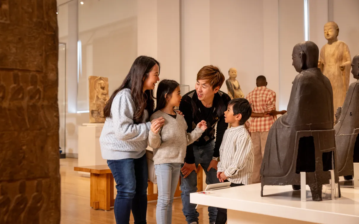 Family of four looking at object in China Gallery