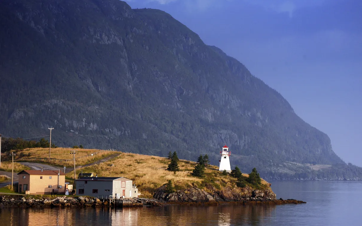A lighthouse with a mountain in the background.