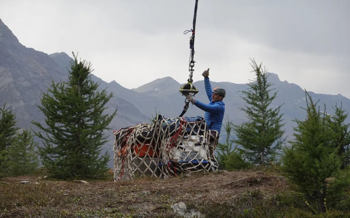 Crates being lifted by helicopter.