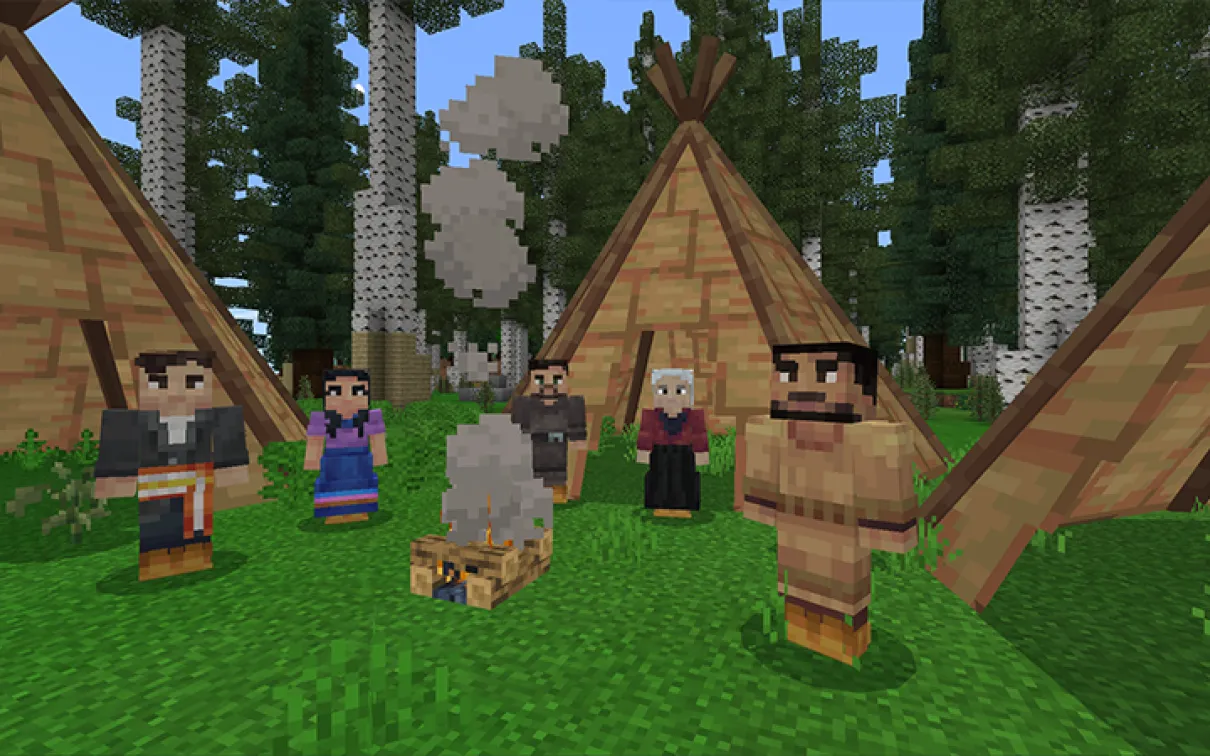 A Minecraft screenshot of several characters in Indigenous dress standing around a campfire in front of wigwaams.