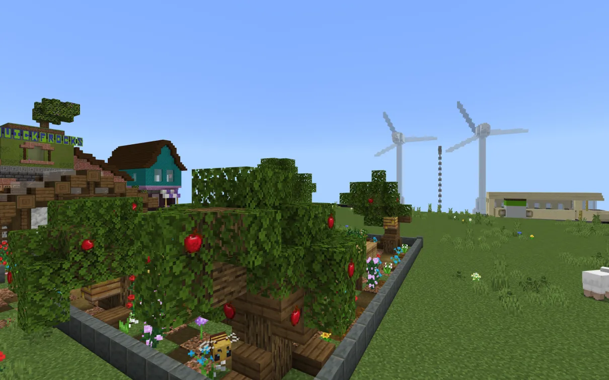 A Minecraft screenshot of a community garden with windmills visible in the background.