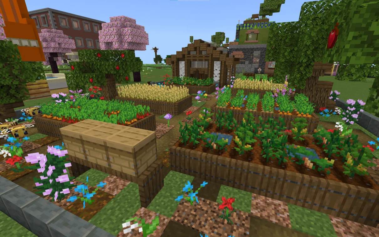 A Minecraft screenshot of a garden containing vegetable plots, flowers, beehives, and a greenhouse.