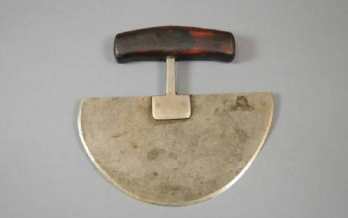 A dark brown handle is attached by a crosspiece to a semicircular metal blade.