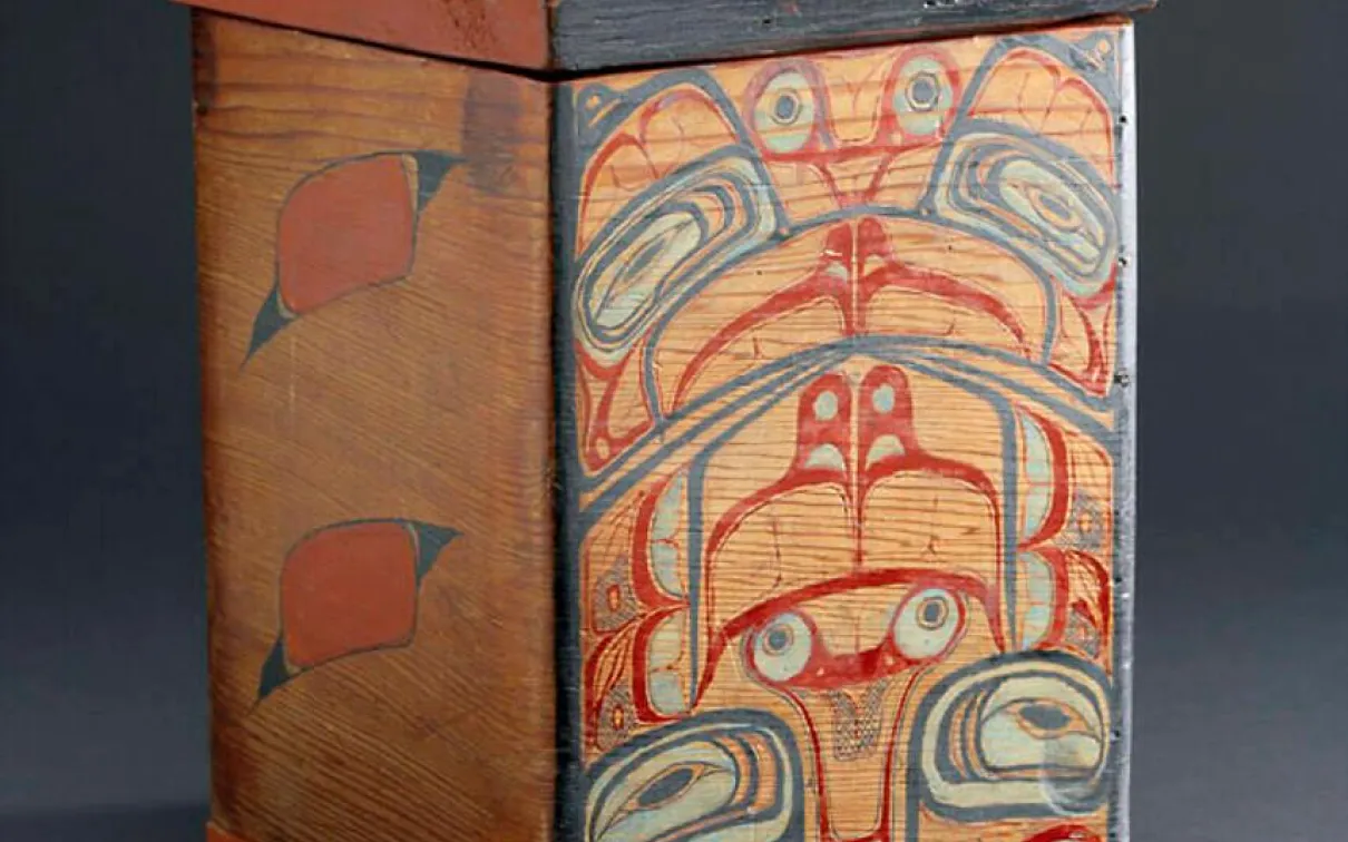 A box made of red wood painted in designs of red, black, and white.
