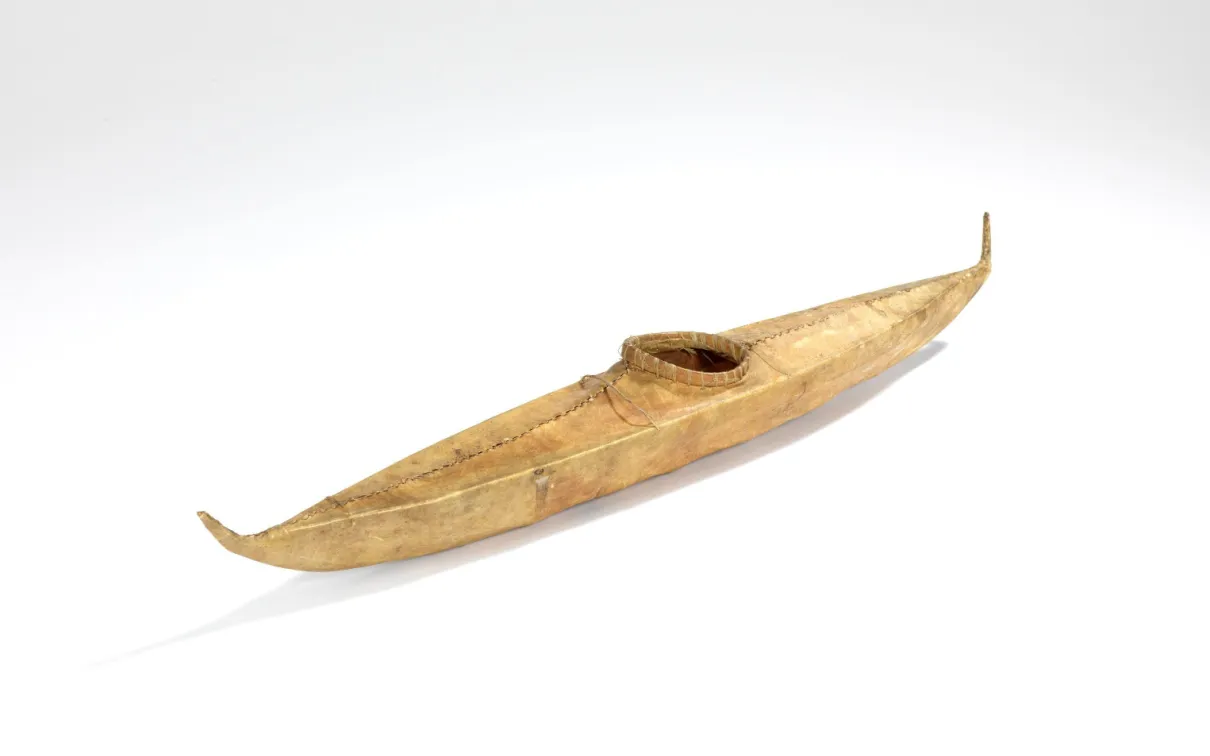 A 43 cm model of a kayak covered in light brown skin sewn together with sinew.