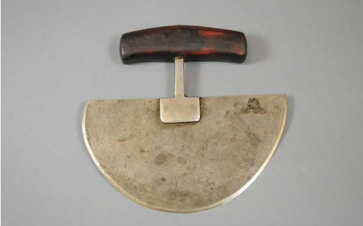 A knife with a metal blade shaped as a semi-circle, connected to a wooden handle.