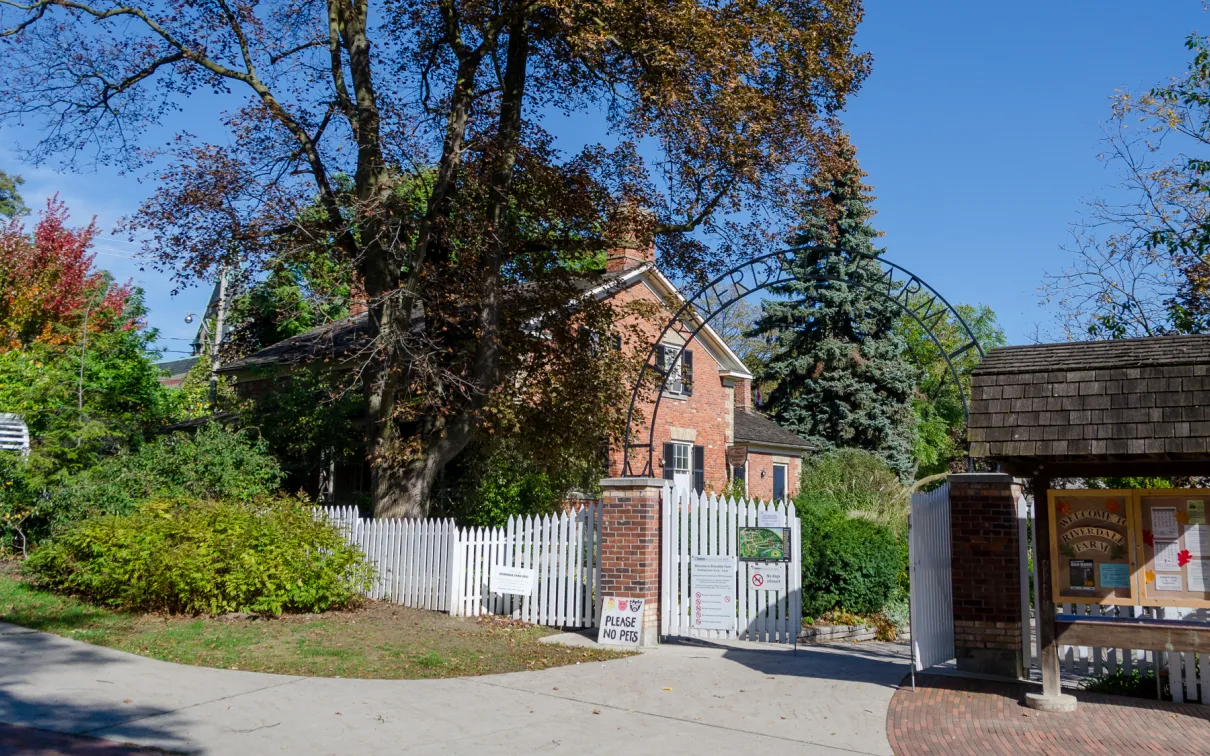 Entrance to Riverdale farm with gate in foreground and building in backgroun