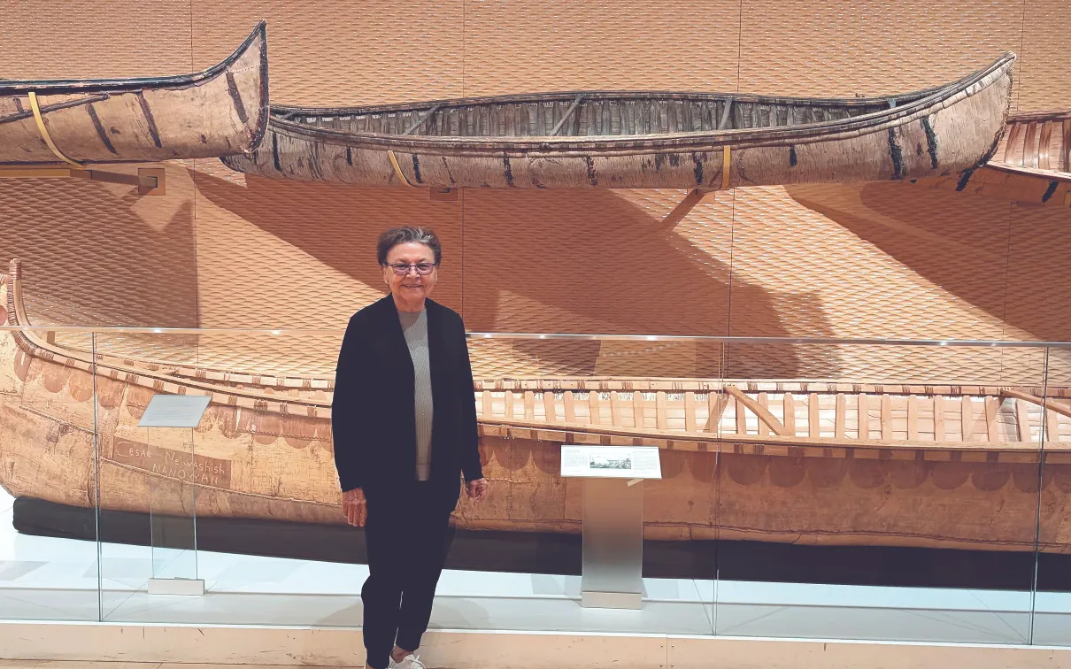 Barbara Nolan, the inaugural Elder in Residence, stands in the Daphne Cockwell Gallery dedicated to First Peoples art & culture. 