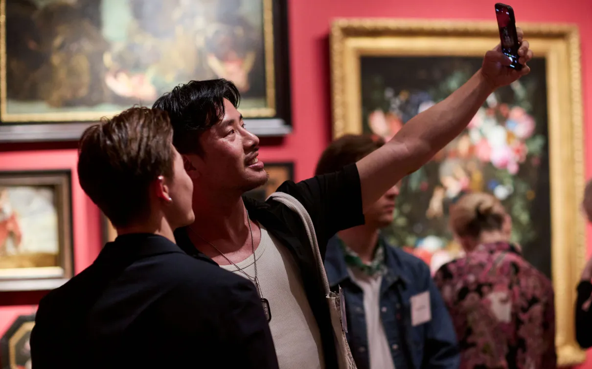 Patrons taking a selfie at an exhibition opening