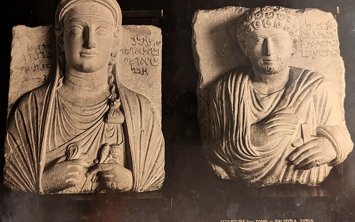 Left: Limestone stele depicting a woman with long hair and rectangular face; right: Limestone stele depicting a man with curly hair and beard, both wearing draped garments and seated.