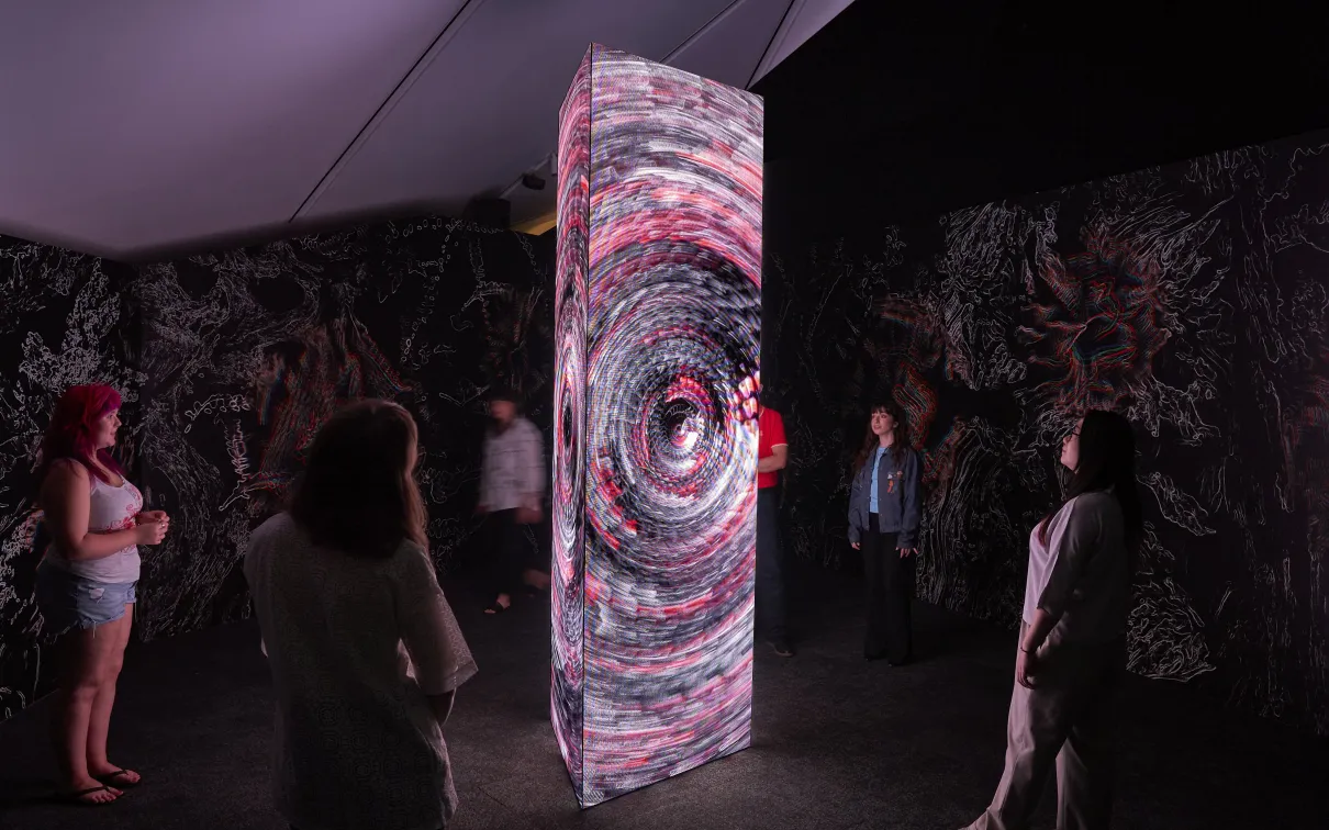 image of people looking at video monolith inside exhibition