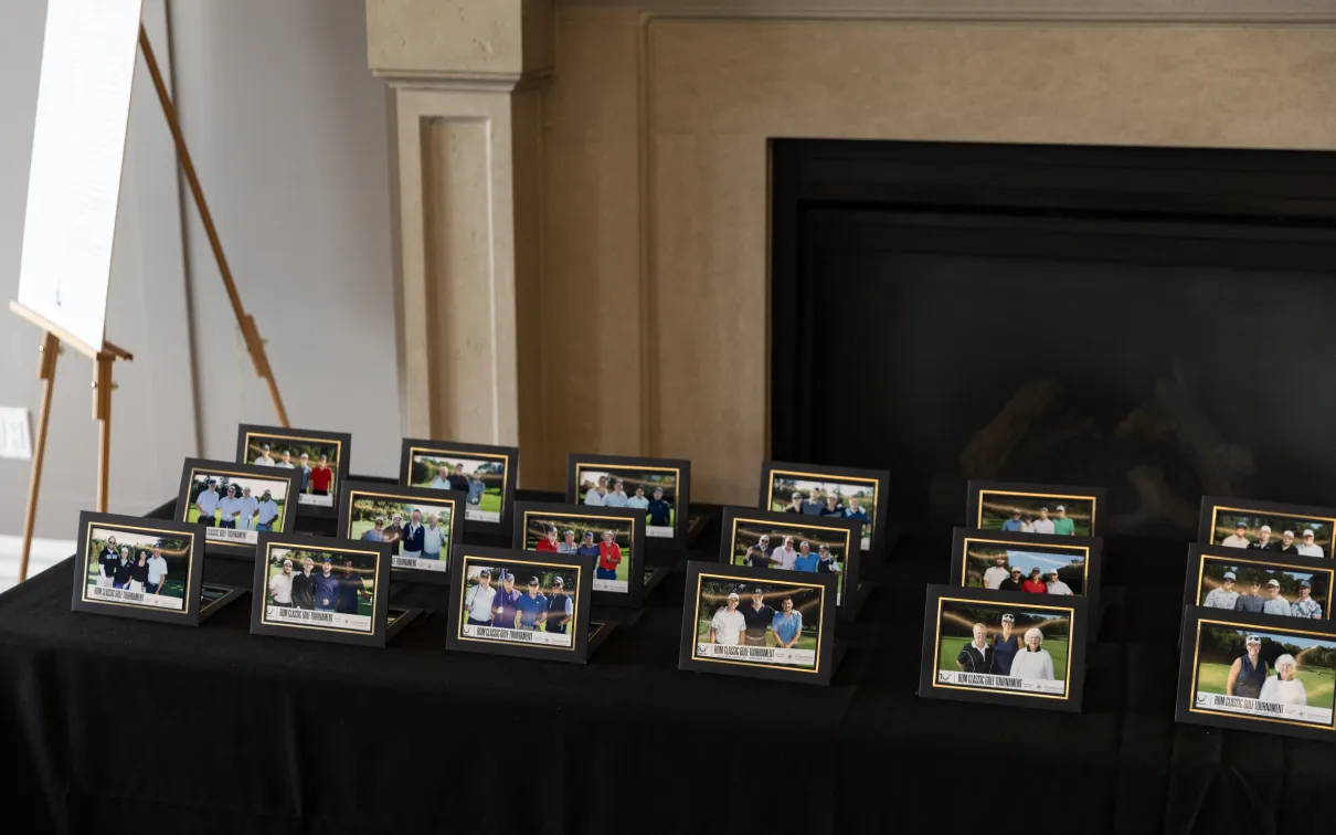 Foursome photos laid out on a table from the 10th Annual Classic Golf Tournament