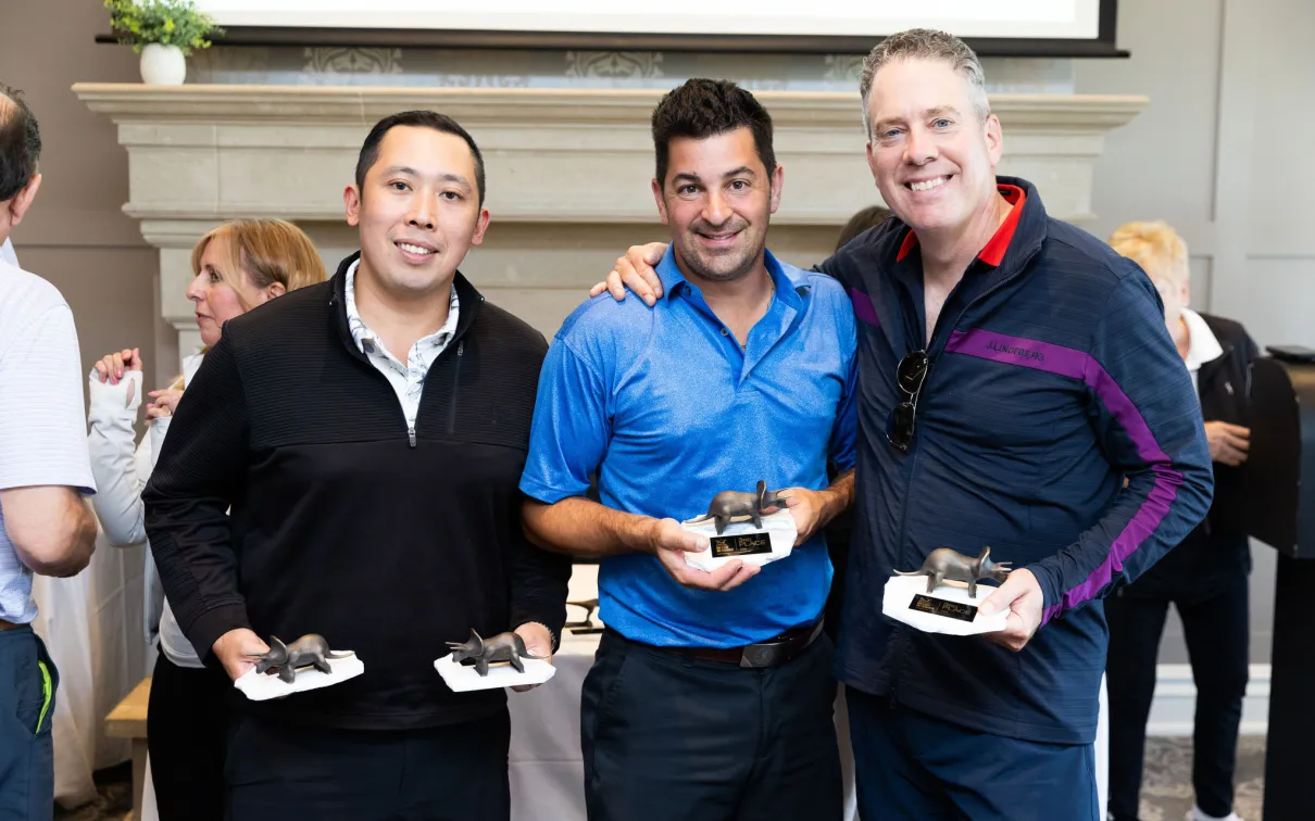 3 men holder the 3rd place foursome trophies. 