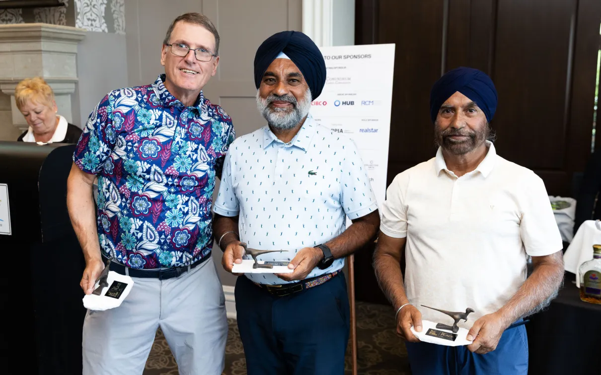 Three men holding the Raptors 1st place trophies.