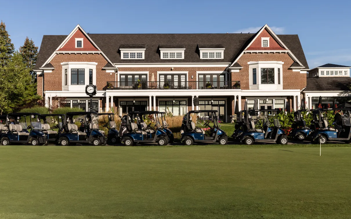 Cedar Brae golf club with player golf carts parked in front. 