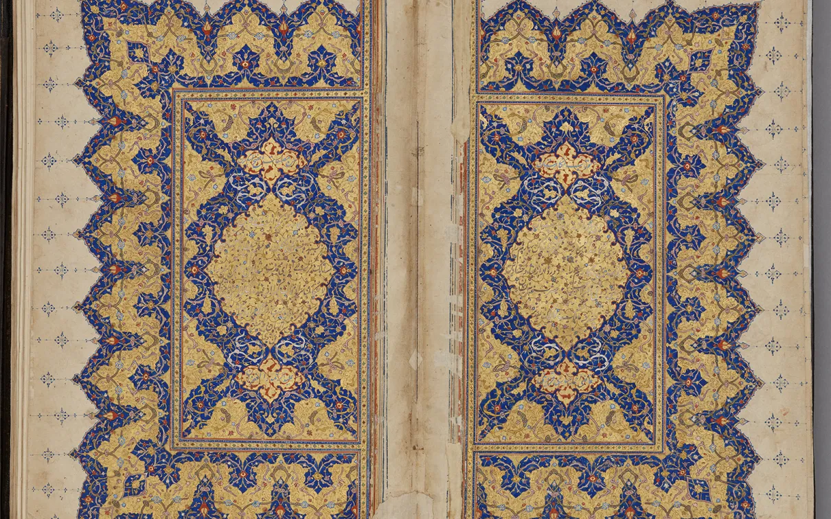 A book page covered in intricate geometric blue and red illumination with red accents.