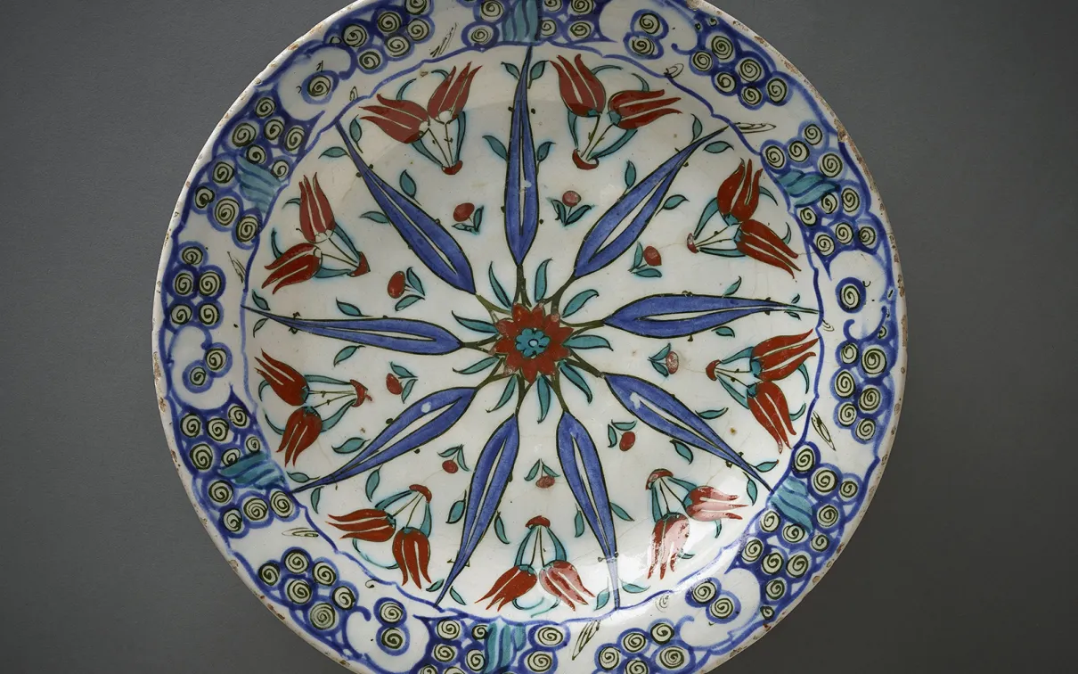 A dish featuring a radial geometric design featuring tulips.