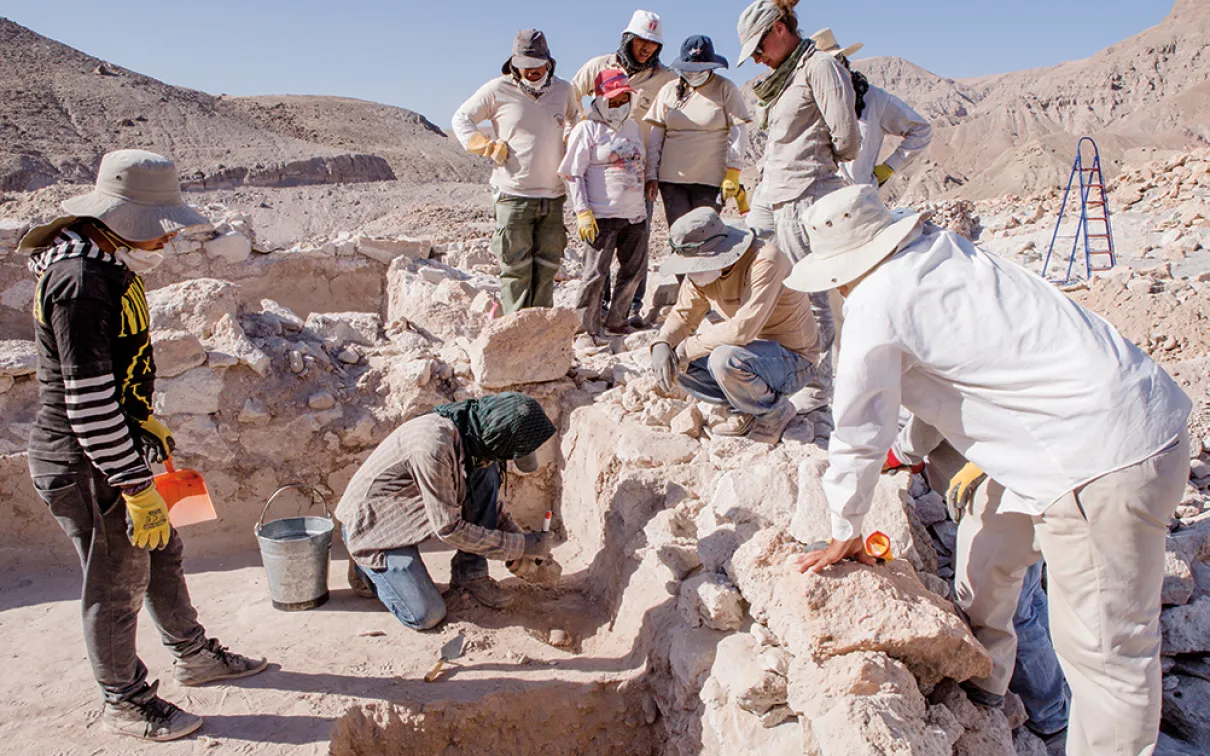 The team gathers around Maico Aybar Villalobos as he dusts off a stunning face-neck jar. 
