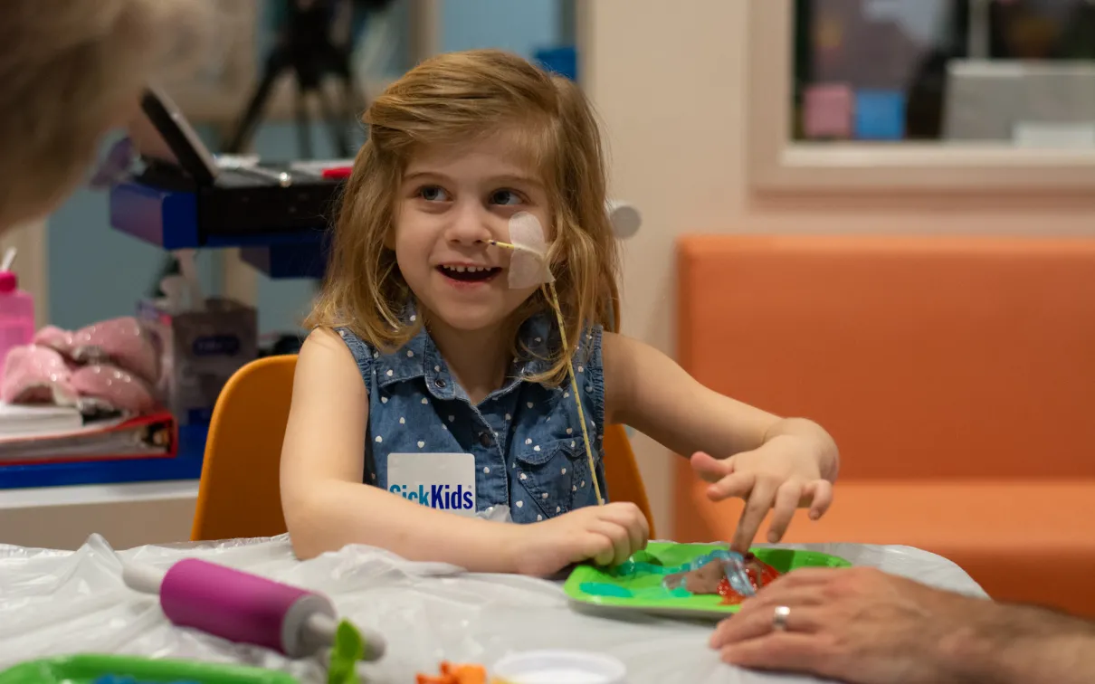 Photo of a girl at Sick Kids doing a dinosaur craft. Photo credit Mark Bernards3
