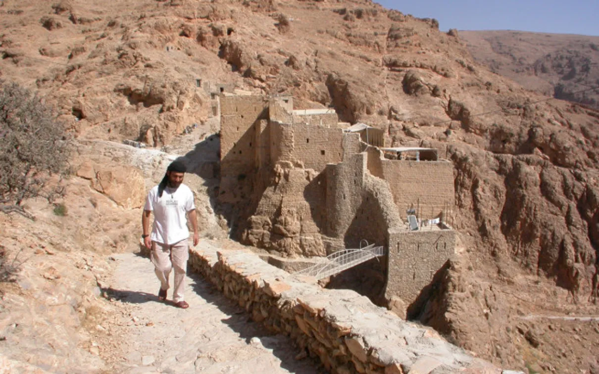 View of the old monastery buildings from the South in 2004, with then Brother Jihad, a member of the monastery.
