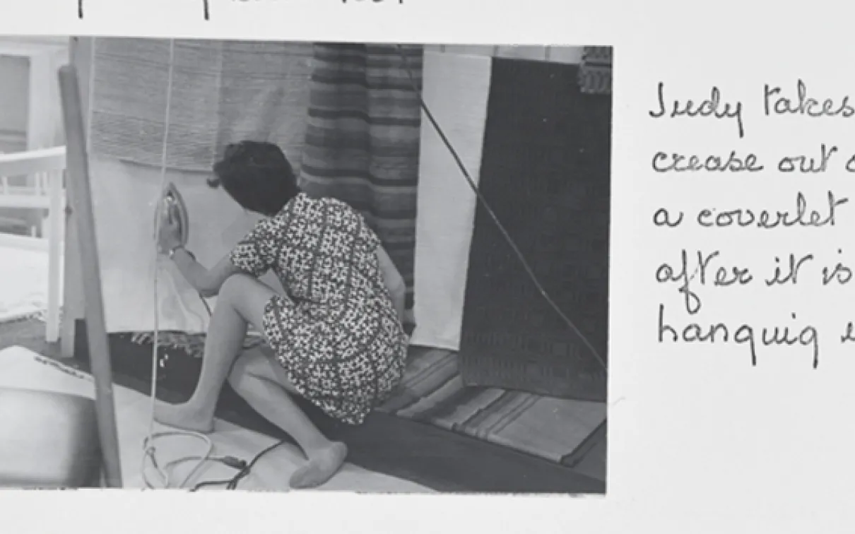 "Judy takes a crease out of a coverlet after it is hanging up."
