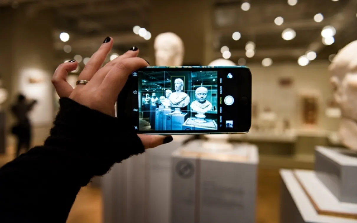 Image of a visitor taking a photo on a smartphone

