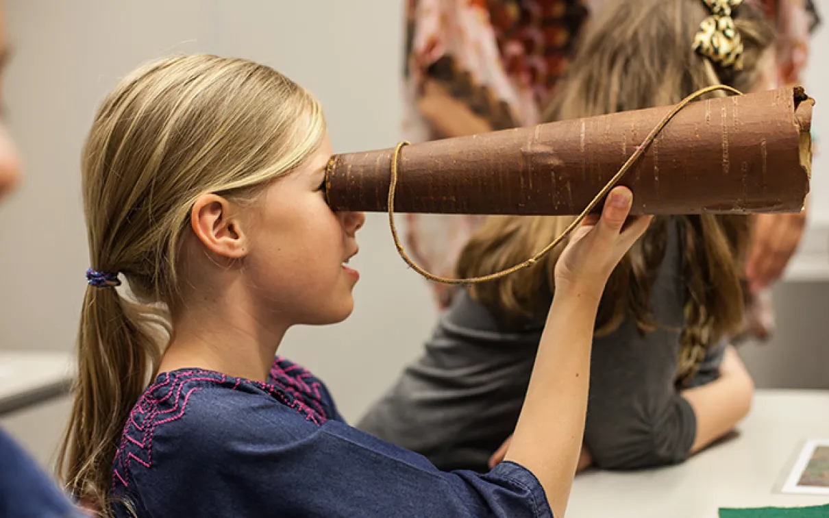 Girl looking through a telescope