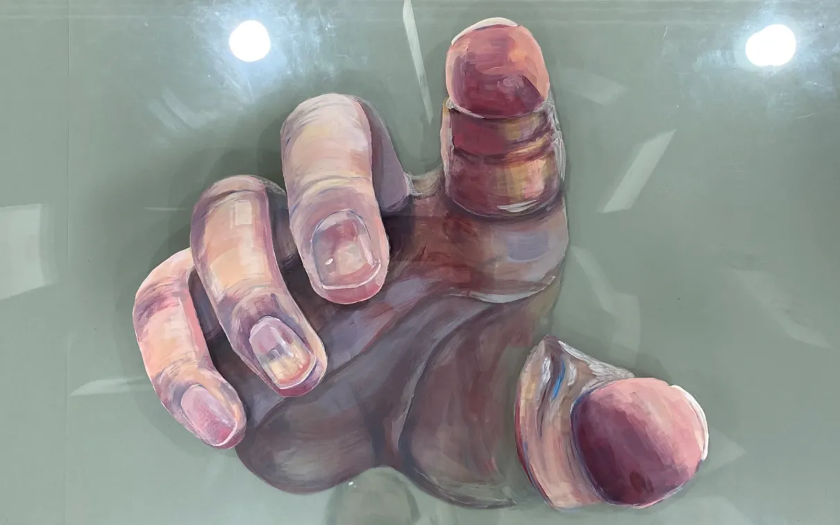 Painting on glass depicting a hand reaching towards the viewer shown on a green/blue background.