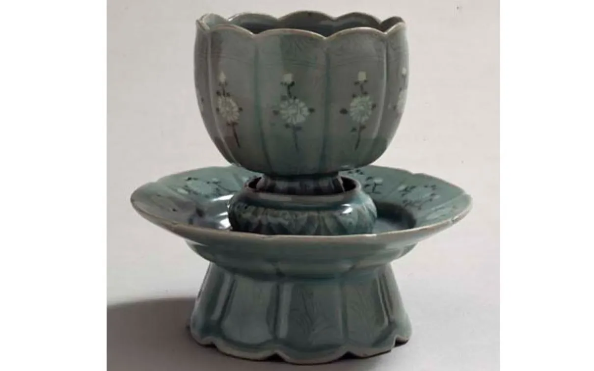 Overall frontal view of a Celadon glazed stoneware cup on a white background