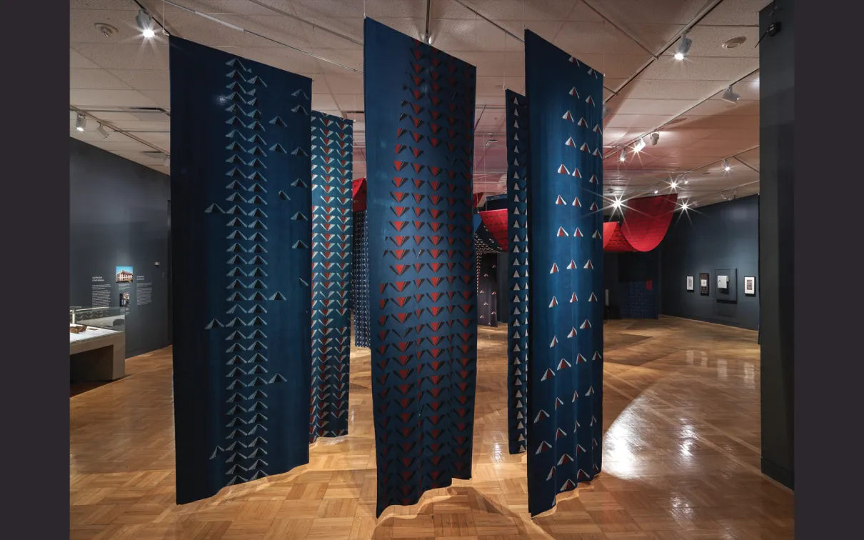 Section de panneaux suspendus en tissu de coton bleu imprimé dans l'exposition Swapnaa Tamhane : Mobile Palace, au ROM.