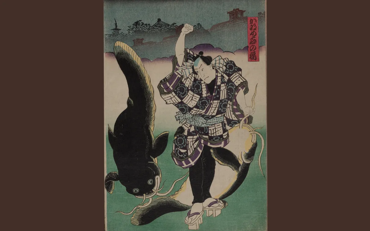 An actor dressed as Fuku of Kaname-ishi stands, grasping the barbel of a large, subdued catfish in one hand, and raising his other fist to strike a second large catfish.