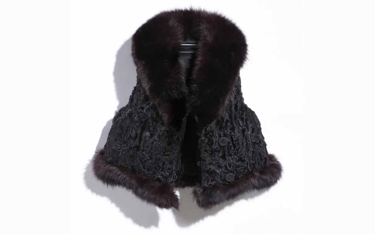 Image of a repurposed life jacket covered in black fur. Image taken on a white background.
