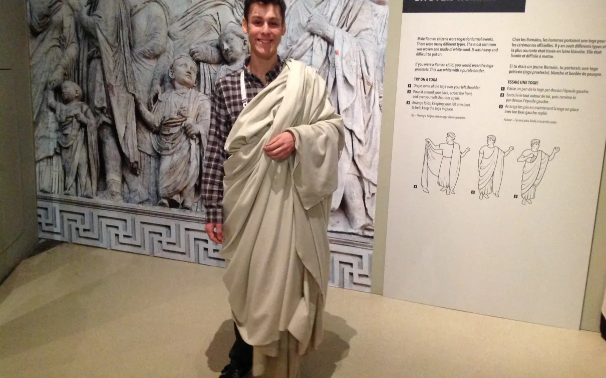 Un jeune homme porte une toge blanche
