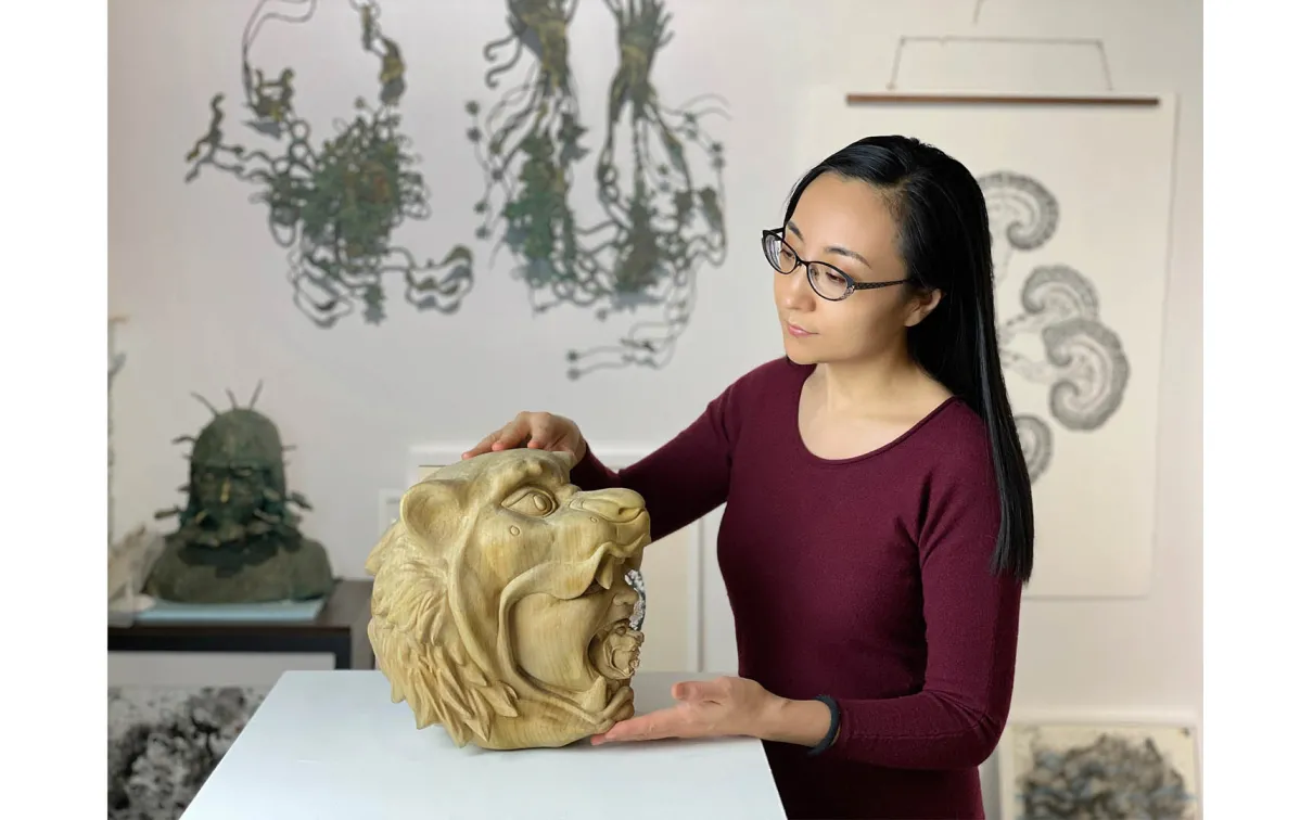 Artisit examining her sculpture.