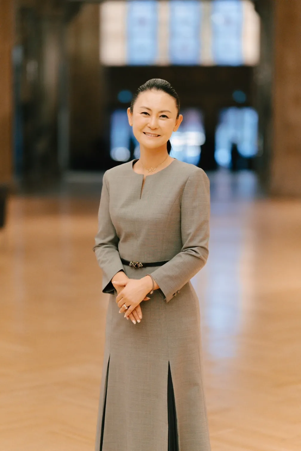  A woman, Hyon Chu Lee, stands at the Korea Gallery gift announcement at the Royal Ontario Museum. She is dressed formally and smiling softly. 