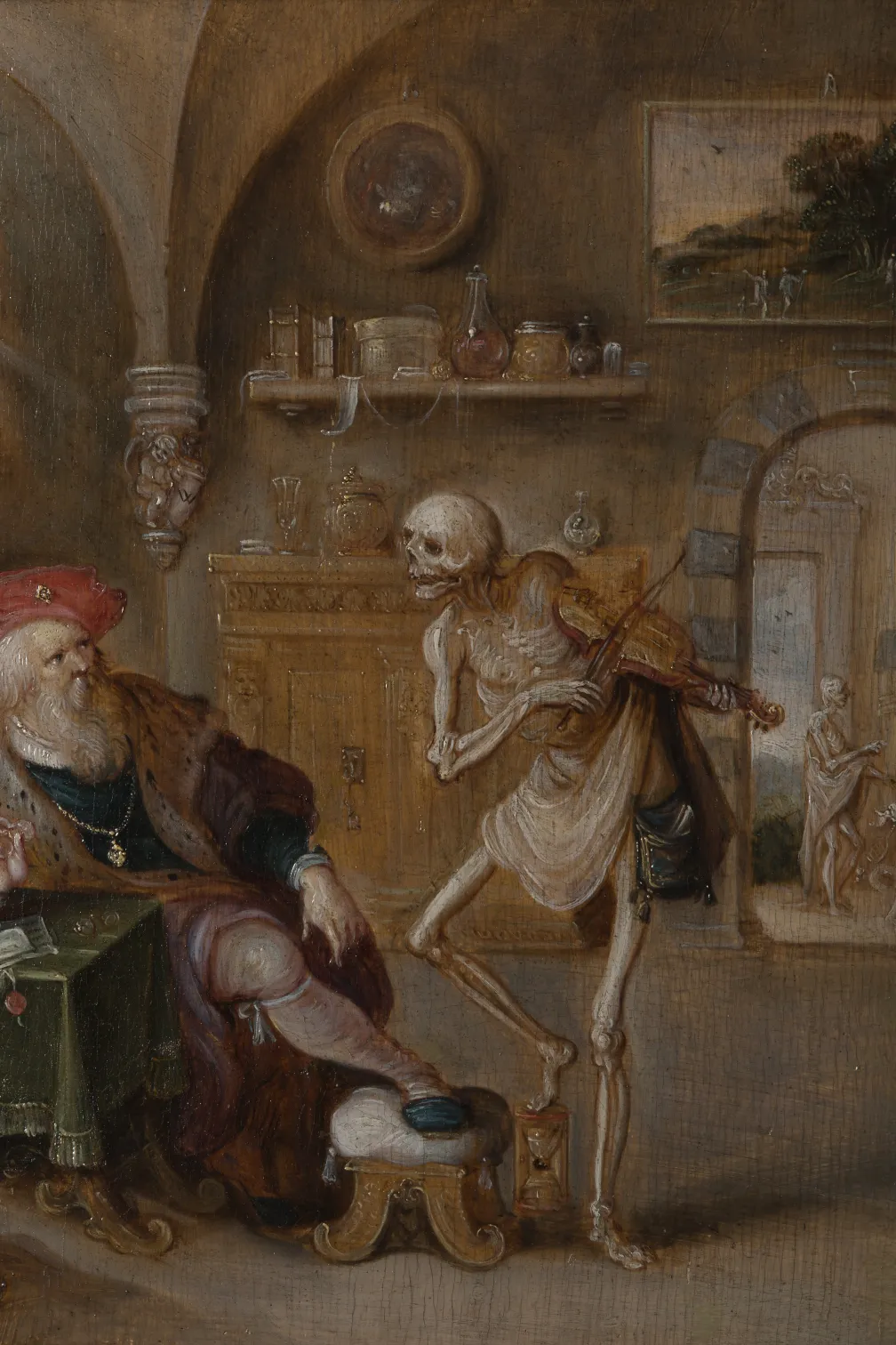 A seated merchant, in rich robes and red hat, recoiling from a skeleton playing a violin before him with one foot on an hourglass.
