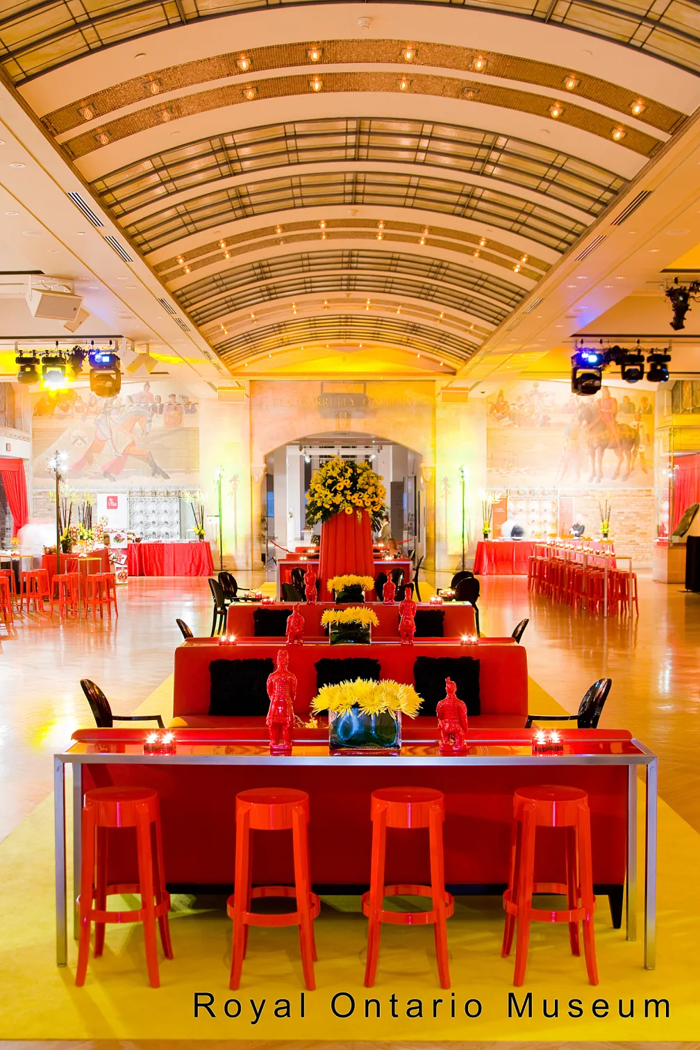 A room filled with red chairs and tables in the Currely Gallery of Royal Ontario Museum.