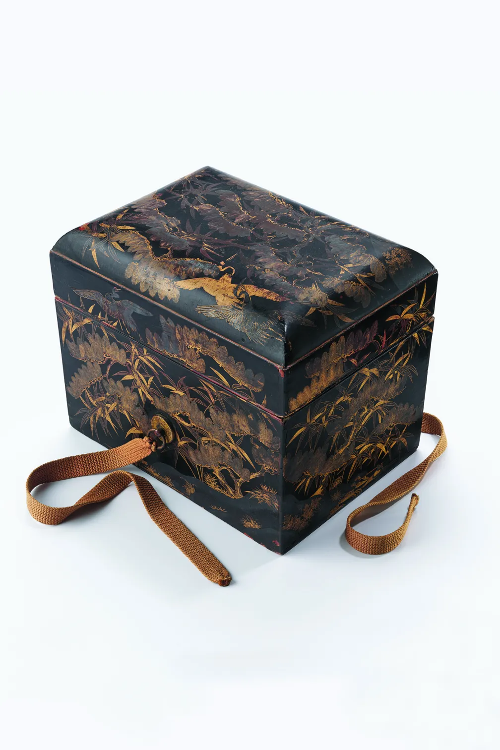 Rectangular black lacquer box decorated with intricate gold illustrations of birds, grasses, and foliage on the lid and sides, with two brown cord ties attached, photographed on a white background with soft, even lighting. 