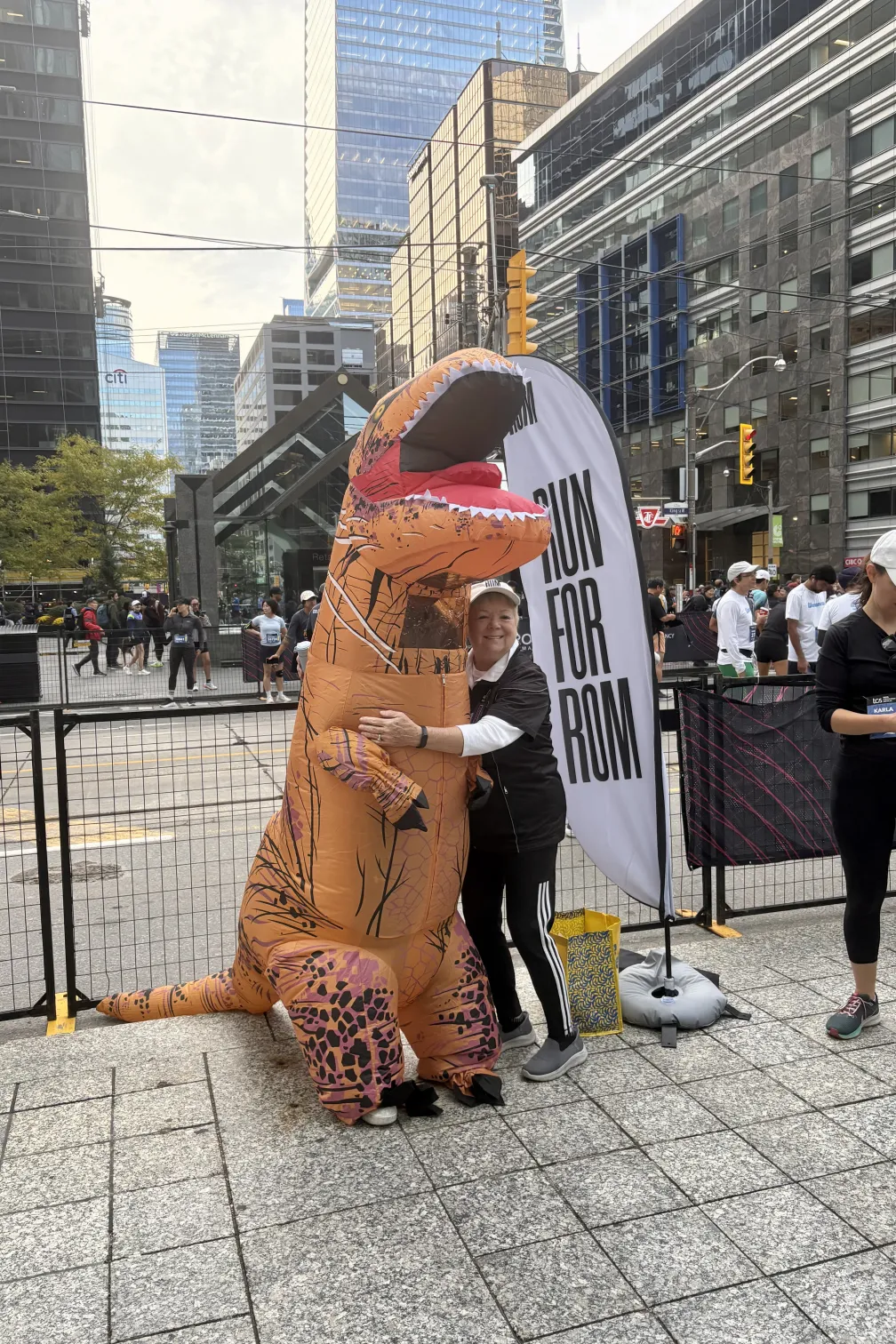 Janice Price, President and CEO of ROM Governors hugging the Run for ROM mascot prior to running in the 5K. 